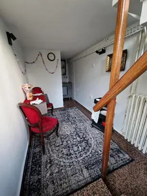 a living room with a staircase and a red chair at Gallery House in Belgrade