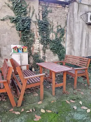 two wooden benches and a picnic table and a stove at Gallery House in Belgrade