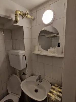 a bathroom with a sink and a toilet and a mirror at Gallery House in Belgrade