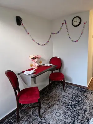 a room with a table and two chairs and a clock at Gallery House in Belgrade