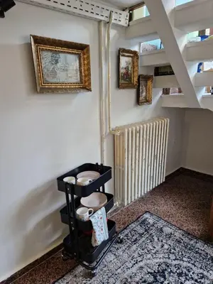 a room with a staircase with a hat on a shelf at Gallery House in Belgrade