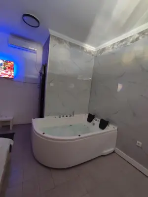 a white bath tub in a bathroom with blue lights at Sunset in Pančevo
