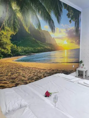 a white bed on a beach with a mural at Sunset in Pančevo