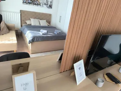a bedroom with a bed and a tv in a room at Gallery Mall View-studio in Belgrade