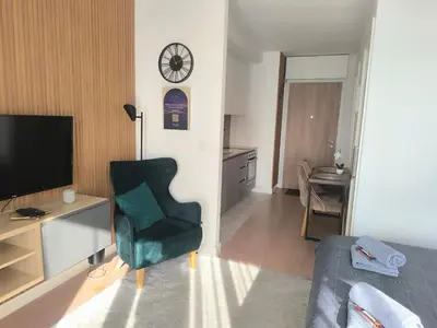 a living room with a couch and a chair and a television at Gallery Mall View-studio in Belgrade