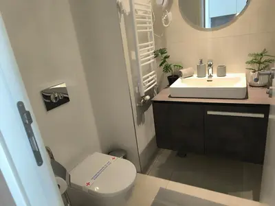 a bathroom with a white toilet and a sink at Gallery Mall View-studio in Belgrade