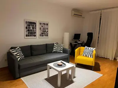 a living room with a gray couch and a yellow chair at Belville city view in Belgrade