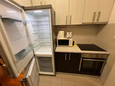 a small kitchen with a refrigerator and a microwave at Belville city view in Belgrade