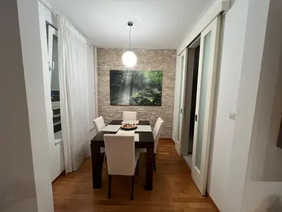 a dining room with a black table and white chairs at Belville city view in Belgrade