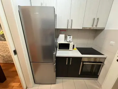 a stainless steel refrigerator in a kitchen with a microwave at Belville city view in Belgrade
