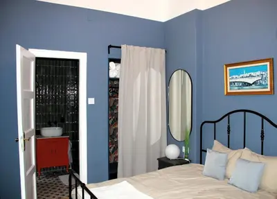 a bedroom with blue walls and a bed and a mirror at Belgrade 1920 in Belgrade