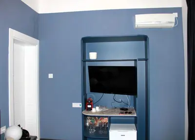 a blue wall with a television in a room at Belgrade 1920 in Belgrade