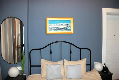 a bedroom with blue walls and a bed with white pillows at Belgrade 1920 in Belgrade