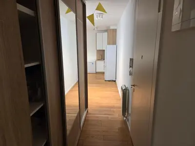a hallway leading to a room with a kitchen and a hallway at Apartman-Stan in Belgrade
