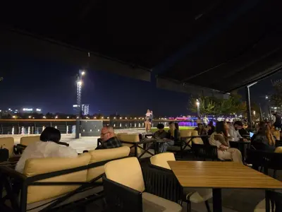 a group of people sitting at a restaurant at night at Apartman-Stan in Belgrade