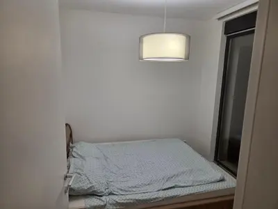 a small bed in a room with a window at Apartman-Stan in Belgrade