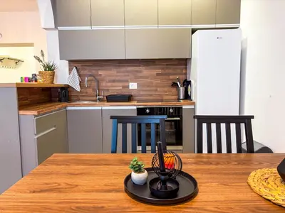 a kitchen with a wooden table with a counter top at Lukerly 2 in Belgrade