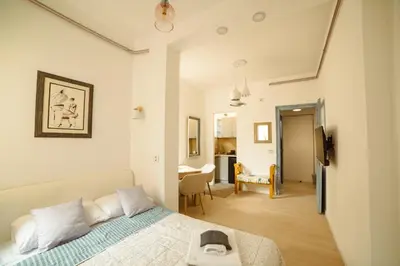 a bedroom with a bed and a dining room at Mizi Apartment in Belgrade