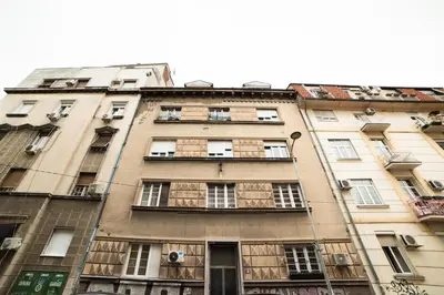 a tall building with windows on the side of it at Mizi Apartment in Belgrade