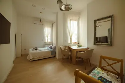a bedroom with a bed and a table and a mirror at Mizi Apartment in Belgrade