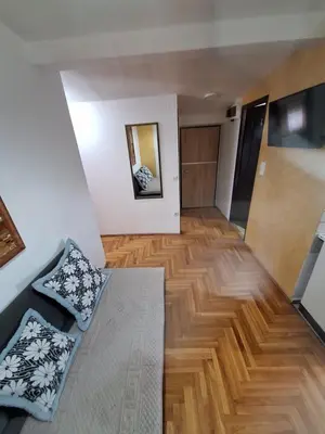 a living room with a couch and a wooden floor at Rooms3 in Beograd
