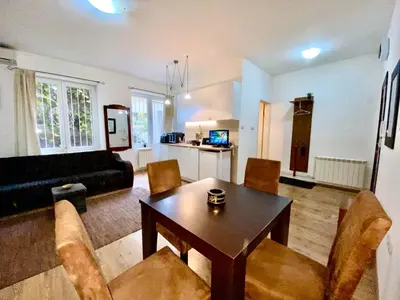 a living room with a wooden table and chairs at Center Belgrade in Belgrade