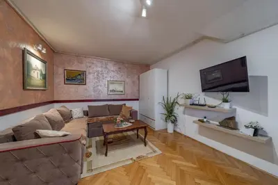 a living room with a couch and a tv at Ada Home Belgrade Apartment