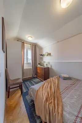 a bedroom with a bed and a chair and a window at Ada Home Belgrade Apartment