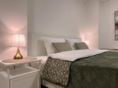 a bedroom with a bed with a lamp on a table at Liberte Apartments 2 Voždovac in Belgrade