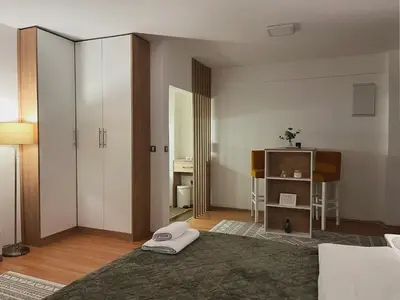 a bedroom with a bed and a room with a desk at Liberte Apartments 2 Voždovac in Belgrade