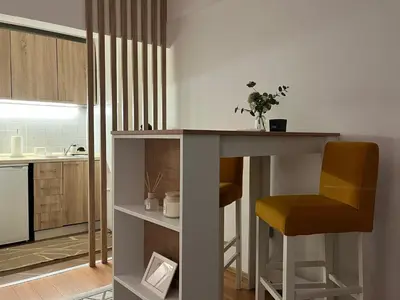 a small kitchen with a table and a chair at Liberte Apartments 2 Voždovac in Belgrade