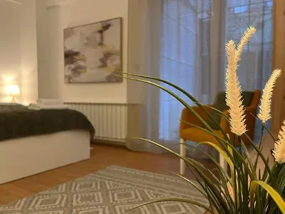 a living room with a vase with a plant in it at Liberte Apartments 2 Voždovac in Belgrade