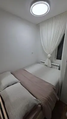 a bedroom with two beds and a window at Apartman Beograd in Belgrade