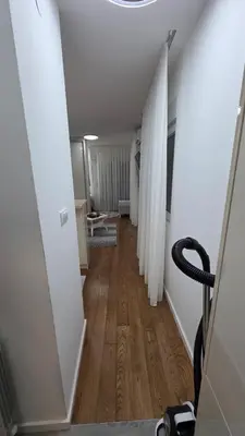 a long hallway with white walls and wooden floors at Apartman Beograd in Belgrade