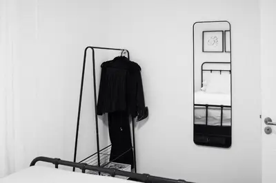a mirror hanging on a wall next to a bed at Villa Vista Slankamen in Stari Slankamen