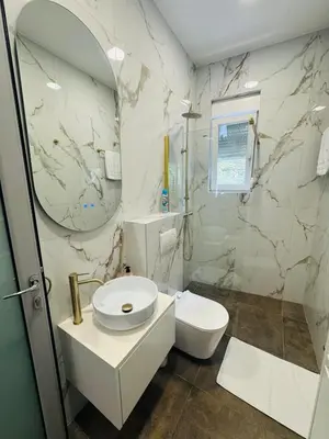 a bathroom with a toilet and a sink and a mirror at WhiteCity Suite in Belgrade