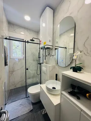 a bathroom with a shower and a toilet and a sink at WhiteCity Suite in Belgrade