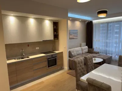 a kitchen and living room with a couch and a table at Belgrade Waterfront River & City View Apartment in Belgrade