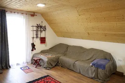 a bed in a room with a wooden ceiling at Vila Dinara in Krčedin