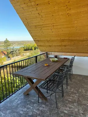 a wooden table and chairs on a balcony at Vila Dinara in Krčedin