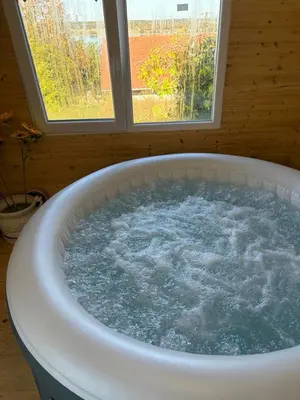 a tub with water in it in front of a window at Vila Dinara in Krčedin