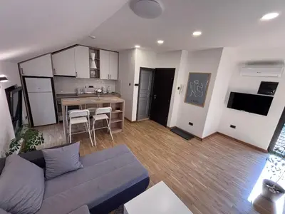 a living room with a couch and a kitchen at Pejton Apartment in Belgrade