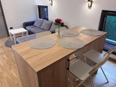 a living room with a table with a vase of flowers on it at Pejton Apartment in Belgrade