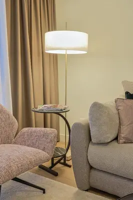 a living room with a chair and a lamp at The Sensation Belgrade Waterfront in Belgrade