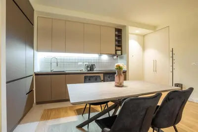 a kitchen with a dining room table and chairs at The Sensation Belgrade Waterfront in Belgrade
