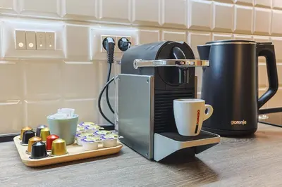 a coffee maker sitting on a counter with a tray of cups at The Sensation Belgrade Waterfront in Belgrade