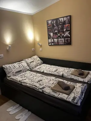 a bedroom with two beds and a picture on the wall at Crown Apartment in Belgrade