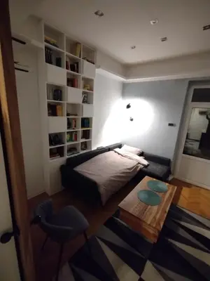 a bedroom with a bed and a chair and a table at Vuk i Vojvoda in Belgrade