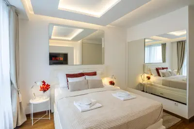 a bedroom with a large white bed and a mirror at Bw Lux Apartments River view in Belgrade