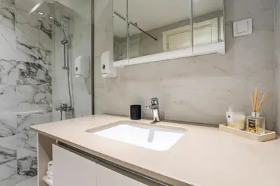 a white bathroom with a sink and a mirror at Bw Lux Apartments River view in Belgrade